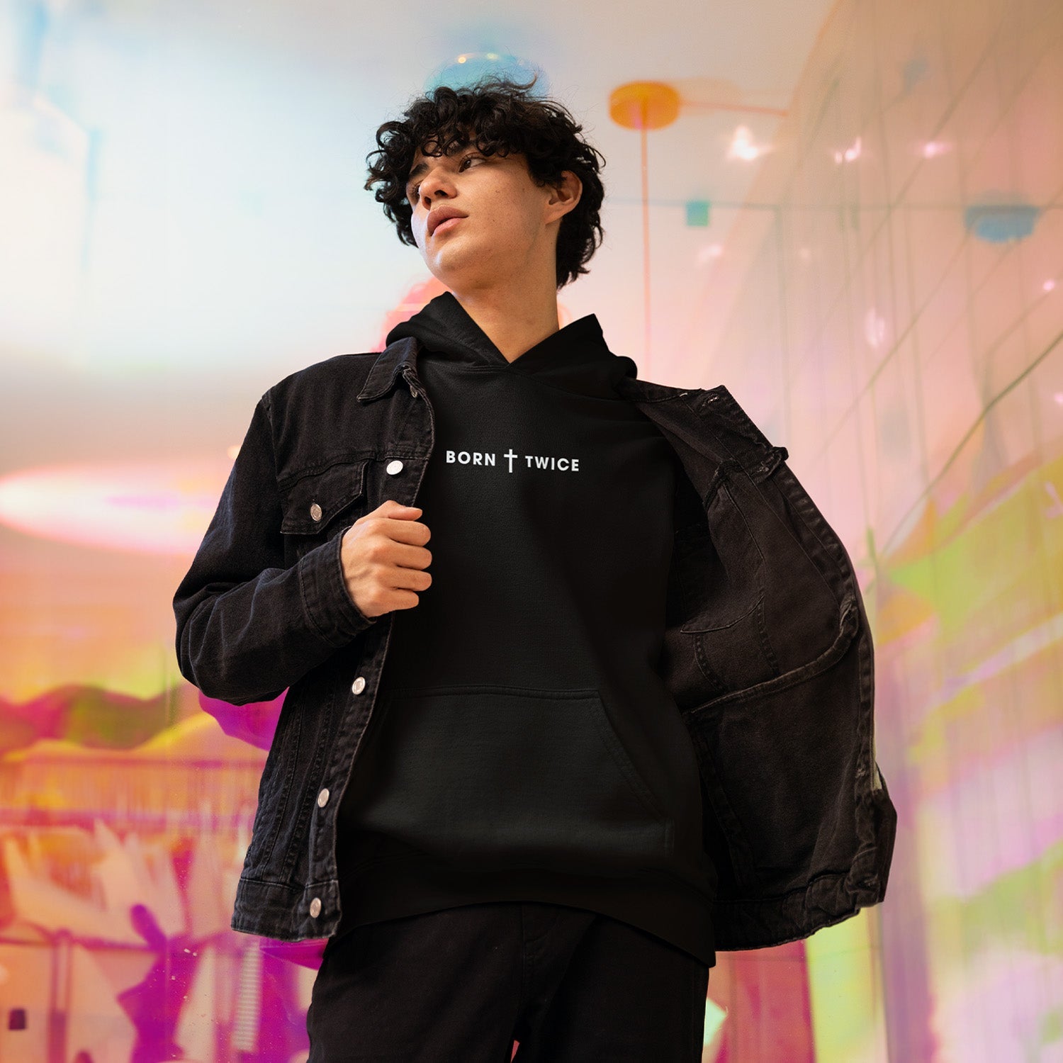 A young person wearing a black Born Twice Hoodie